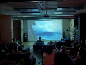 a group of people sitting in a room watching a movie at Bethlehem City Hostel in Bethlehem