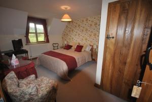 une chambre d'hôtel avec un lit et une chaise dans l'établissement Elms Farm, à Alderton
