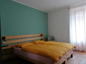 1 dormitorio con 1 cama grande y cabecero de madera en ALPINO B&B en Chiesa in Valmalenco