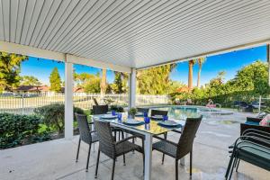 a patio with a table and chairs and a pool at Desert Pool House: Sun, Swim, Sip & Stay in Indio