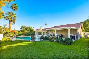 uma casa com uma piscina e um quintal em Desert Pool House: Sun, Swim, Sip & Stay em Indio