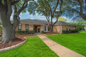 a house with a green lawn and trees at Central Plano 4-BD 2-BA Pool Retreat, Sleeps 10 in Plano