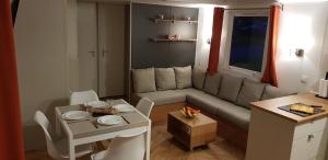 una pequeña sala de estar con sofá y mesa. en MOBILHOME CLIMATISE TOUT CONFORT 6 à 8 PERSONNES à louer, en Litteau