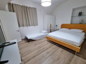 ein Schlafzimmer mit 2 Betten und einem Kühlschrank. in der Unterkunft A casa di Sole in Catania