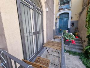 einen Balkon mit zwei Bänken und einer blauen Tür in der Unterkunft A casa di Sole in Catania