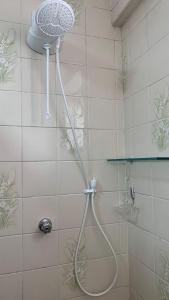 a shower with a shower head in a bathroom at Lindo Apartamento Pé na Areia Canto do Forte in Solemar