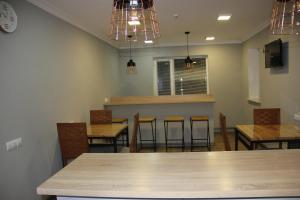 a dining room with tables and chairs and a bar at Hostel 211A in Almaty