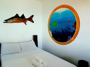 a bedroom with a fish on the wall and a mirror at Morro Beach Hotel in Morro de São Paulo
