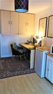 a kitchen with a desk and a chair and a table at 1 Dbl Bed Ground Floor Modern Oriental Flat Greenwich Park in London