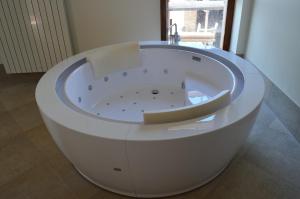 a white bath tub in a room with a window at Relais San Desiderio in Calliano