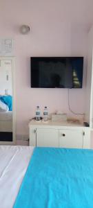 um quarto com uma cama e uma grande televisão na parede em Little Palace BNB em Saint Georgeʼs
