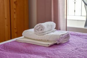 einen Stapel Handtücher auf dem Bett in der Unterkunft Skiathos home with the best view in Skiathos-Stadt