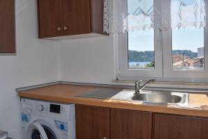 a kitchen with a sink and a washing machine at Skiathos home with the best view in Skiathos +83 photos