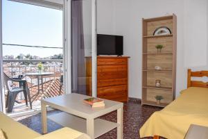 a living room with a bed and a table and a balcony at Skiathos home with the best view in Skiathos