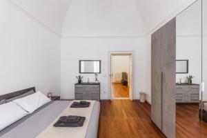 a white bedroom with a bed and a wooden floor at Casa dei Visionari in Bari