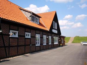 un edificio con techo naranja y ventanas blancas en Hotel Steinhagen en Damnatz