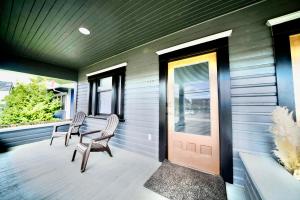 a porch with two chairs and a door at Downtown Boho Revival Home PNW in Albany