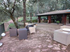 eine Terrasse mit Stühlen und Tischen sowie ein Gebäude in der Unterkunft Hotel Rural Finca Liceo in Mijares