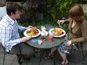 a man and woman sitting at a table eating food at The Globe Inn in Lostwithiel
