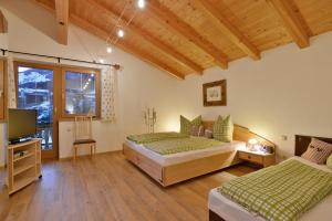 a bedroom with two beds and a television in it at Appartement Kugl in Fügen