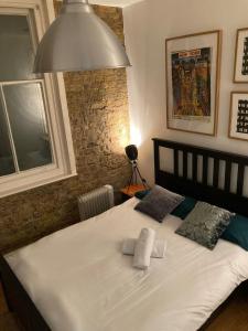 a bedroom with a large white bed with two pillows at Goswell Central Apartment by DC London Rooms in London