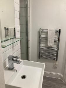 uma casa de banho com lavatório, espelho e toalhas em Goswell Central Apartment by DC London Rooms em Londres