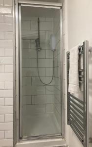 um chuveiro com uma porta de vidro na casa de banho em Goswell Central Apartment by DC London Rooms em Londres