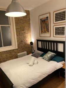 a bedroom with a large white bed with two pillows at Goswell Central Apartment by DC London Rooms in London