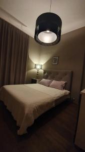 a bedroom with a large bed and a large light at Old Town Apartment in Pärnu
