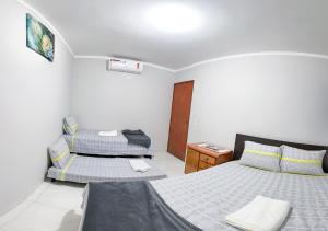 um quarto com 2 camas e uma mesa de cabeceira em Apto com churrasq em Monte Castelo-Campo Grande MS em Campo Grande