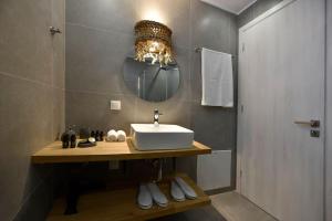 ein Bad mit einem Waschbecken und einem Spiegel in der Unterkunft Kryni Deluxe Houses in Adamas