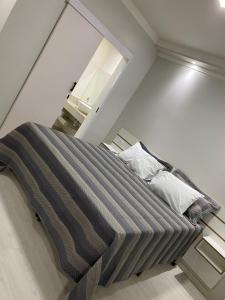 a bed with a striped blanket on it in a room at GUARANY HOTEL PONTA PORÃ in Ponta Porã