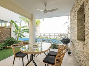 a patio with a table and chairs and a grill at Sanders Aqua Park Resort - Precious 3-Bedroom Holiday Home With Shared Pool in Limassol