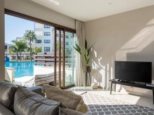 un soggiorno con divano, TV e piscina di Sanders Aqua Park Resort - Precious 3-Bedroom Holiday Home With Shared Pool a Limassol