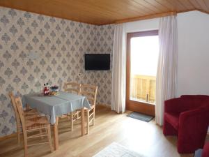 - une salle à manger avec une table, des chaises et une télévision dans l'établissement Ferienwohnung Panorama, à Bad Kohlgrub