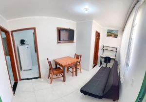 a living room with a table and a tv at Otimo apto c WiFi - Monte Castelo, Campo Grande MS in Campo Grande