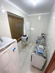 a small kitchen with a stove and a refrigerator at Otimo apto c WiFi - Monte Castelo, Campo Grande MS in Campo Grande