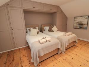 a bedroom with two beds with towels on them at Donni Hall Cottage in Chathill