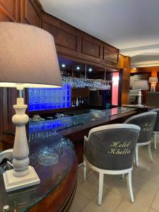 um bar com uma mesa com cadeiras e um candeeiro em Hotel Khella em Hammamet