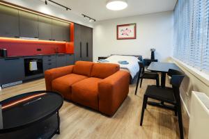 a bedroom with a couch and a bed and a kitchen at Studio 501 in Kaunas