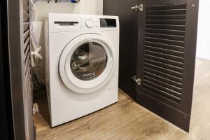een witte wasmachine in een kamer met een deur bij Studio 501 in Kaunas
