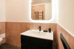 een badkamer met een wastafel en een spiegel bij Studio 501 in Kaunas +8 foto's