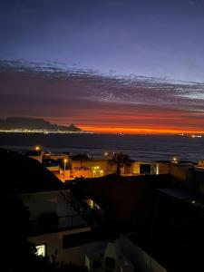 a view of the ocean at night with the sun setting at Gull on the Bay Boutique Guest House in Bloubergstrand