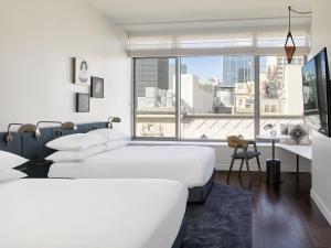 een slaapkamer met 2 bedden en een groot raam bij Kimpton Alma San Diego, an IHG Hotel in San Diego