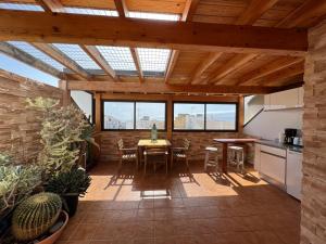 a kitchen and dining room with a table and some plants at Casa Natalie in El Cotillo