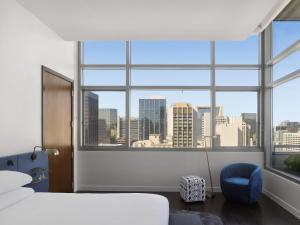 a bedroom with a large window with a city view at Kimpton Alma San Diego, an IHG Hotel in San Diego