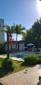 un patio con piscina, palmeras y un edificio en La Alamanda en Federación