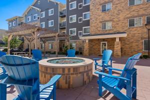 a patio with blue chairs and a fountain in front of a building at WaterWalk- Kansas City- Overland Park in Overland Park