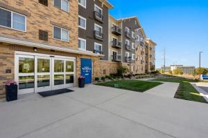 un edificio de apartamentos con garaje y acera en WaterWalk Extended Stay by Wyndham Kansas City - Overland Pk, en Overland Park