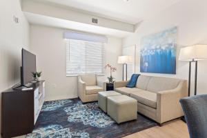 a living room with a couch and a tv at WaterWalk- Kansas City- Overland Park in Overland Park